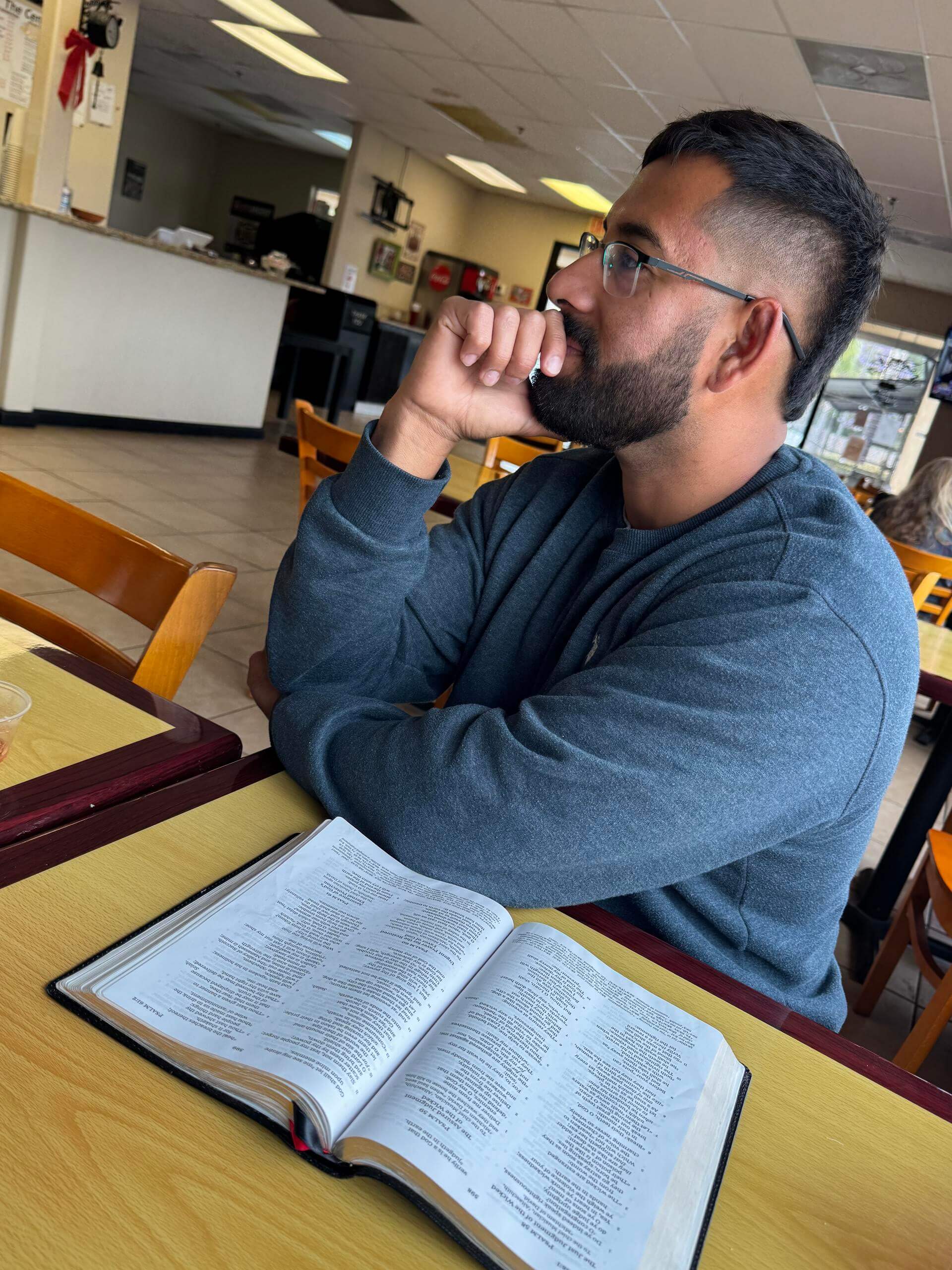 Reading the Bible at a cafe table